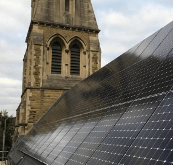 A large set of solar panels placed on the side of a church r town hall building