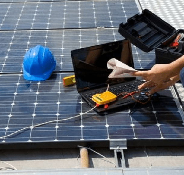 Installing a set of solar panels and checking their diagnostics with a laptop